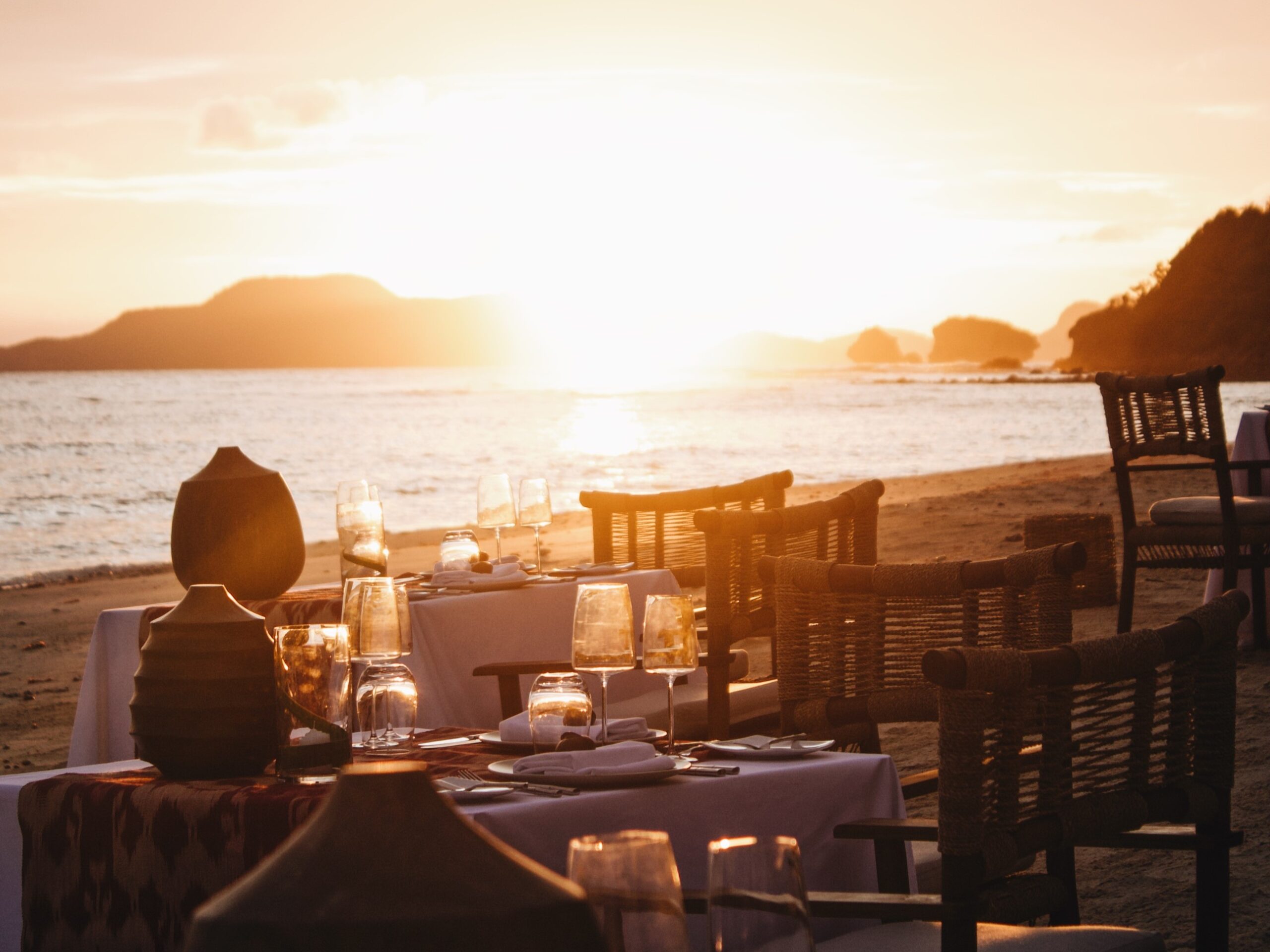 A shot of the beach dinner setup at sunset